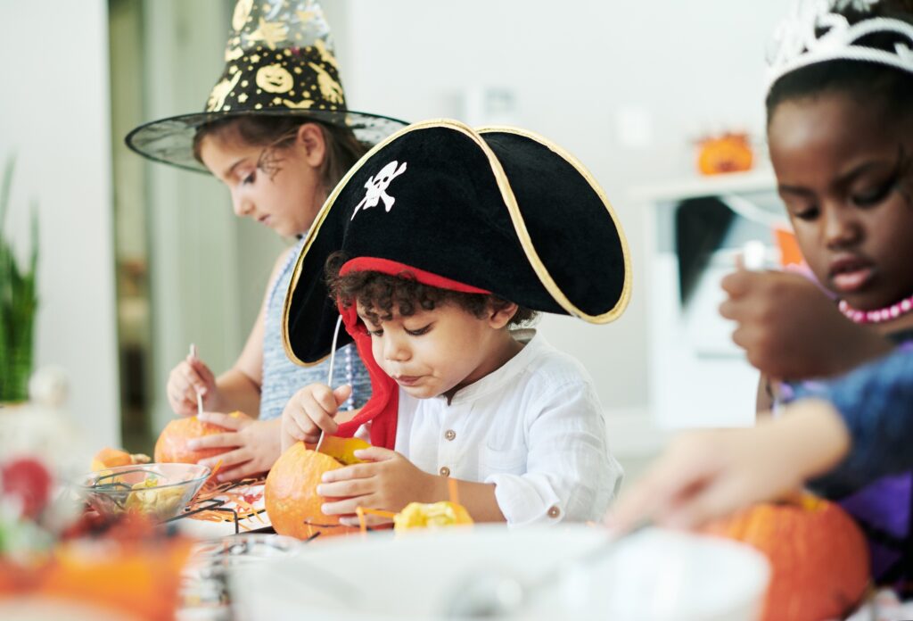 Hard at working. Shot of a group of little children cleaning pumpkins at a party.